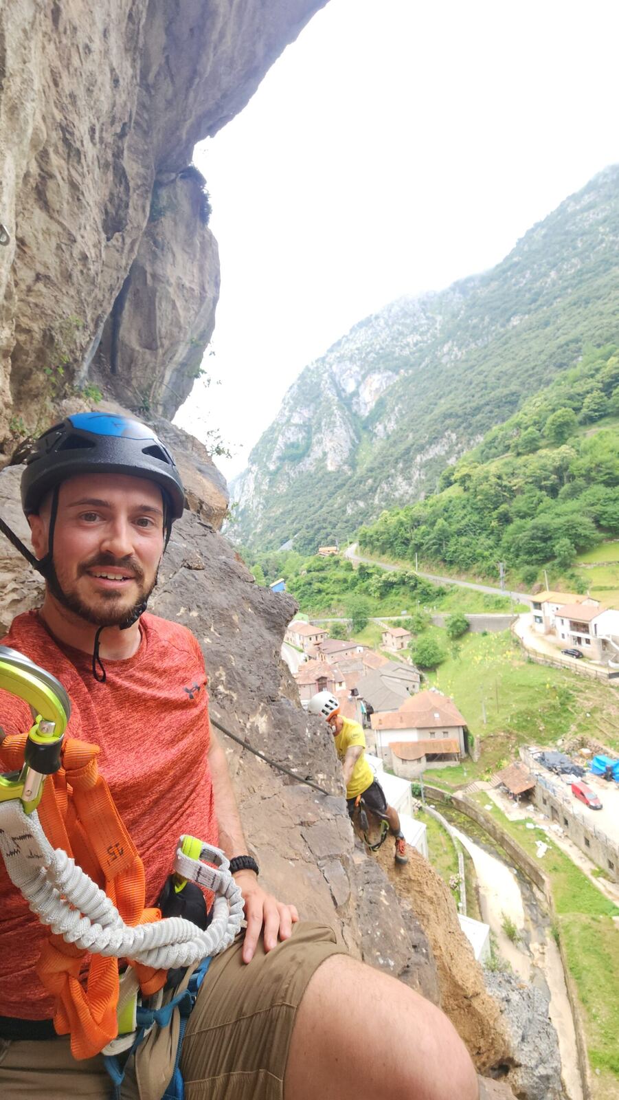 Selfie in a helmet on a cliff above a village