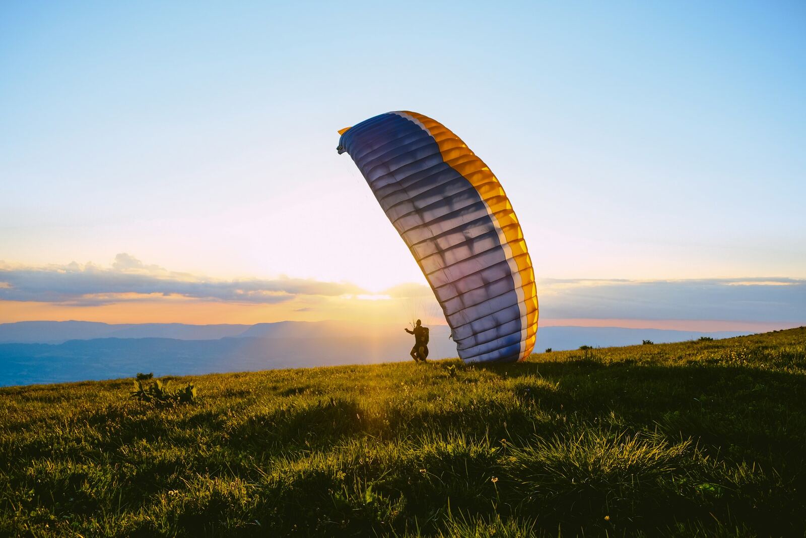 Paraglider launching at sunset