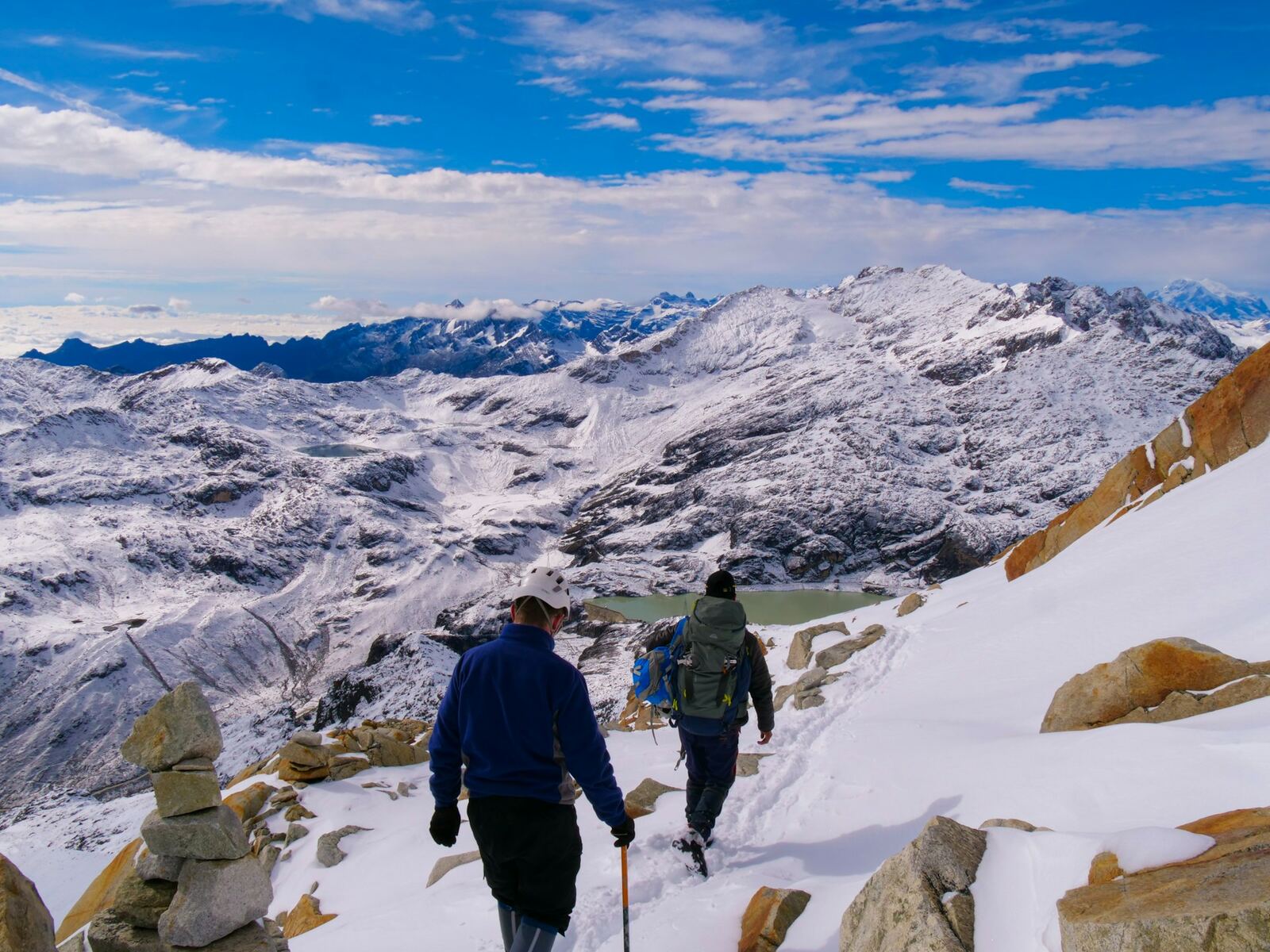 Two hikers crossing snowy mountains